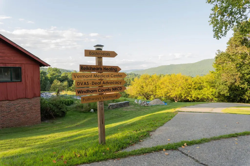 a sign with multiple pointing arrows point to various businesses throughout the village