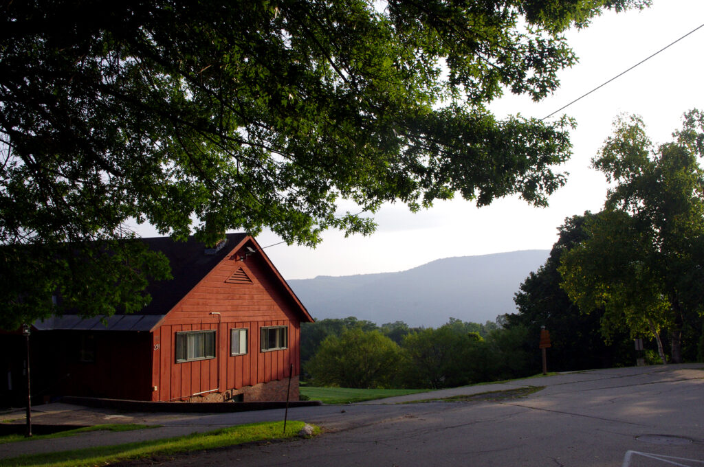 The setting sun hit the red wood of a building overlooking the mountain view
