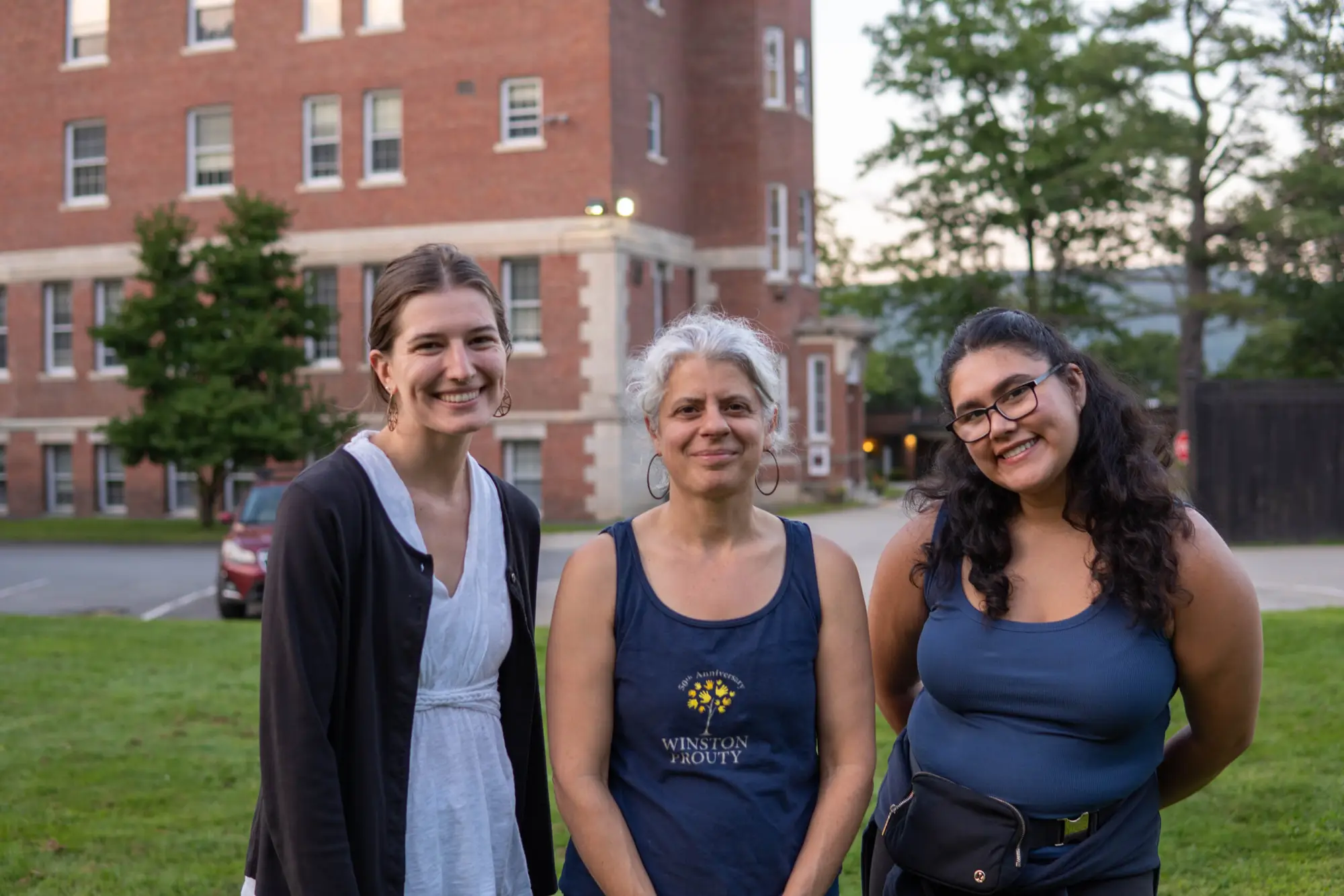 three people stand next to each other smiling at the camera